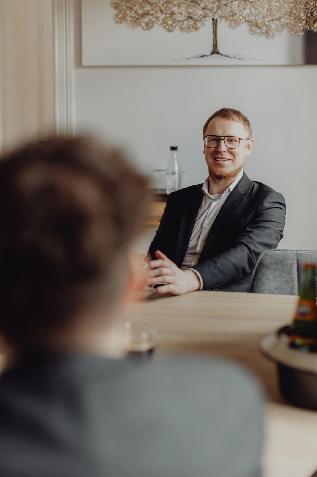 Berater einer Steuer- und Rechtskanzlei im Gespräch mit Mandantin während eines Beratungstermins